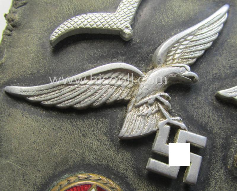 Unusual, WH (Luftwaffe) item that comes as a 'period-souvenir': a part of a leather-based 'wallet' that holds various LW-insignia (such as a visor-cap-eagle, single pip, 'Schwinge' and a: - presumed - LW-'Traditions-Abz.')