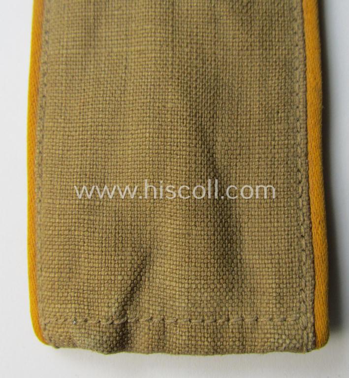 Single, WH (Luftwaffe) tropical-issued, EM-type-shoulderstrap as executed in beige-coloured linnen (as was specifically intended for usage on the tropical-shirts ie. tunics) as was intended for a: 'Soldat der Flieger- o. Fallschirmjäger-Truppen'