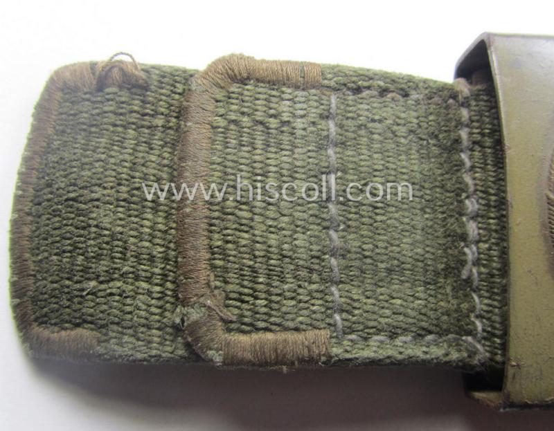 Rarely found WH (Luftwaffe) 'tropical-issued' belt-buckle being a non-maker-marked, beige-tan-coloured example that comes mounted onto its original, greenish-coloured- (and/or: 'webbing'-based-) tab