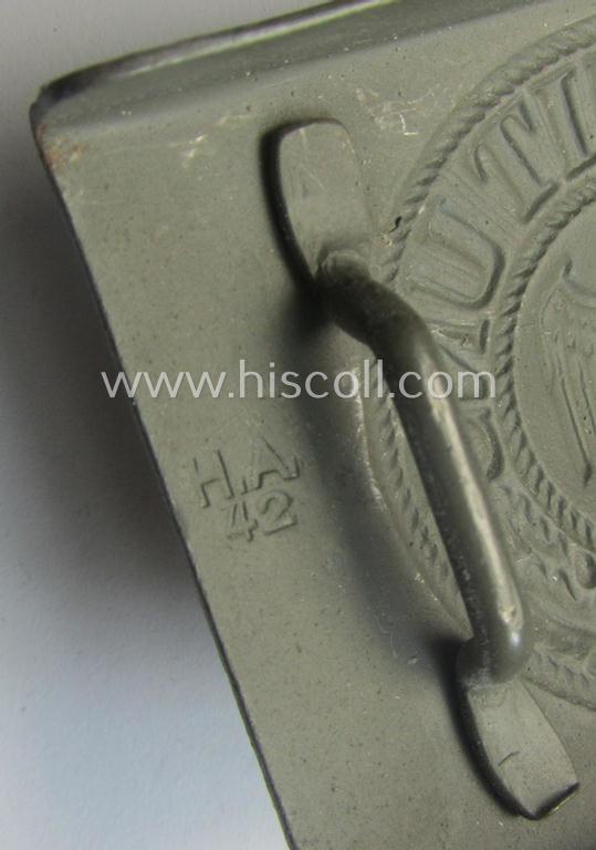 WH (Heeres) 'standard-pattern', field-grey-toned- and steel-based belt-buckle being a maker- (ie. 'H. Arld - Nuernberg'-) marked- and/or: '1942'-dated example that comes mounted onto its leather- (ie. 'pig-skin'-) based tab