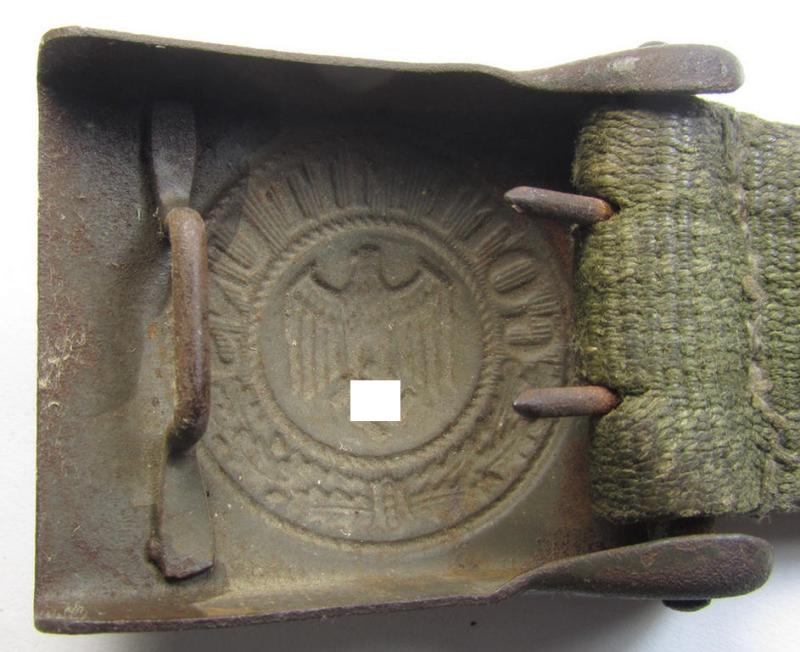 Neat, WH (Heeres) 'tropical-issued' belt-buckle (being a non-maker-marked and/or typical olive-green-coloured) example that comes mounted onto its original, greenish-coloured (and/or: 'webbing'-based-) tab