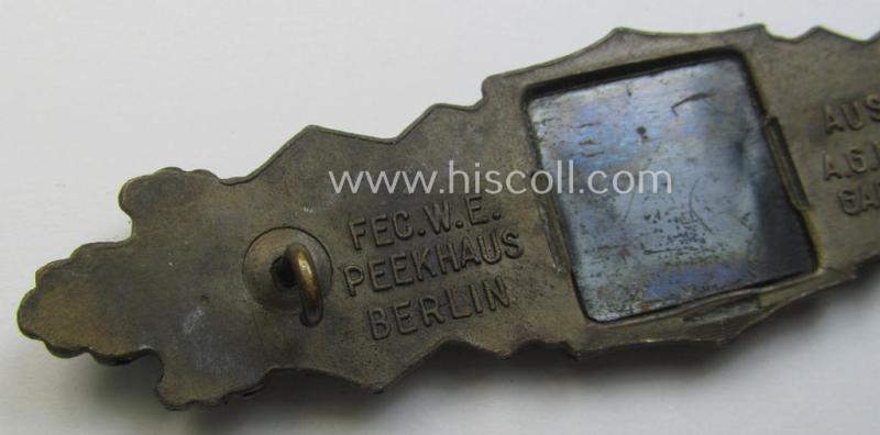 'Nahkampfspange in Bronze' (or: bronze-class close-combat clasp ie. CCC) being a maker- (ie. 'A.G.M.u.K.'-) marked- and/or minimal converse-shaped specimen having its period-attached (bluish-toned and steel-based) 'back-plate' in place