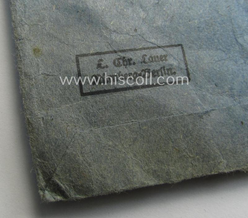 'EK II. Klasse'-set comprising of a non-maker-marked specimen that comes with its ribbon (ie. 'Bandabschnitt') and 'Zellstoff'-based pouch as produced by the company: 'L.Chr. Lauer' (ie. 'Hersteller 14')