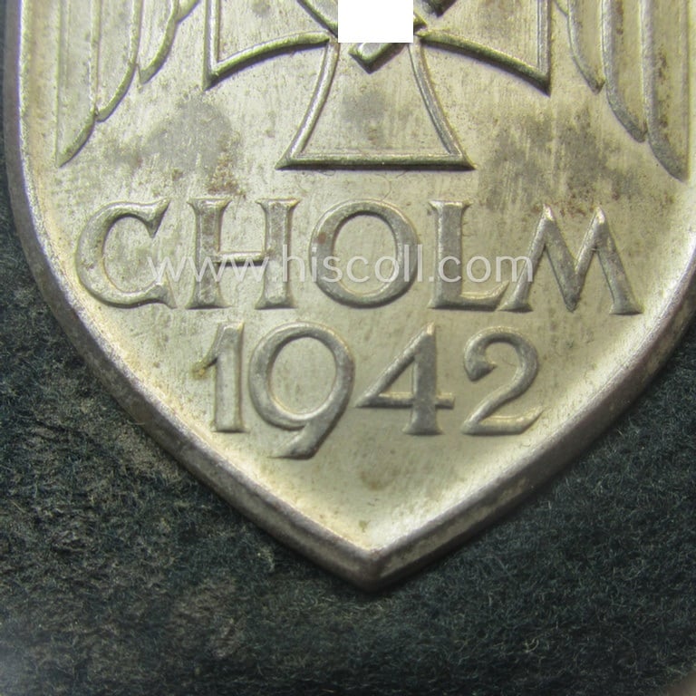 Superb - and truly rarely encountered! - WH (Heeres ie. Waffen-SS) so-called: 'Cholm'-campaign-shield as executed in magnetic, so-called: 'Eisenblech' being a 'Short M-variant-pattern' shield that comes in a clearly used- ie. worn-, condition