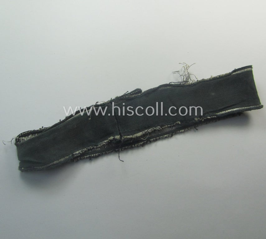 Truly worn- (ie. relic) example of the - rarely encountered! - WH (Heeres) EM- (ie. NCO-) type 'Grossdeutschland'-cuff-title (ie. Ärmelstreifen) being a shortened example of the 1st pattern (as executed in so-called: 'BeVo-flat-wire-woven'-pattern)
