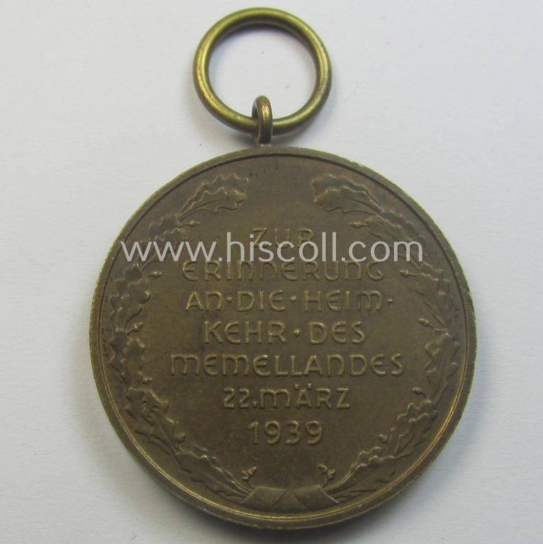 WH Memelland 'Anschluss'- (ie. occupation-) medal: '22 März 1939' (being a minimally used example of the so-called: 'slanted G'-type) that comes together with its original non-confectioned ribbon (ie. 'Bandabschnitt')
