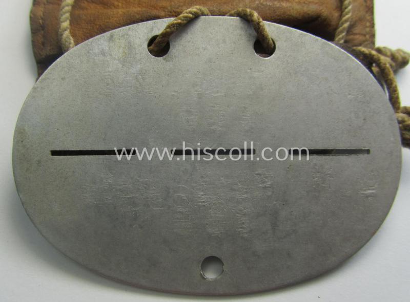 Aluminium-based, WH (Luftwaffe) ie. 'Luftnachrichten'-related ID-disc (ie. 'Erkennungsmarke') bearing the stamped unit-designation that reads: 'L.N. Komp. Wels' and that comes stored in its period (leather-based) pouch