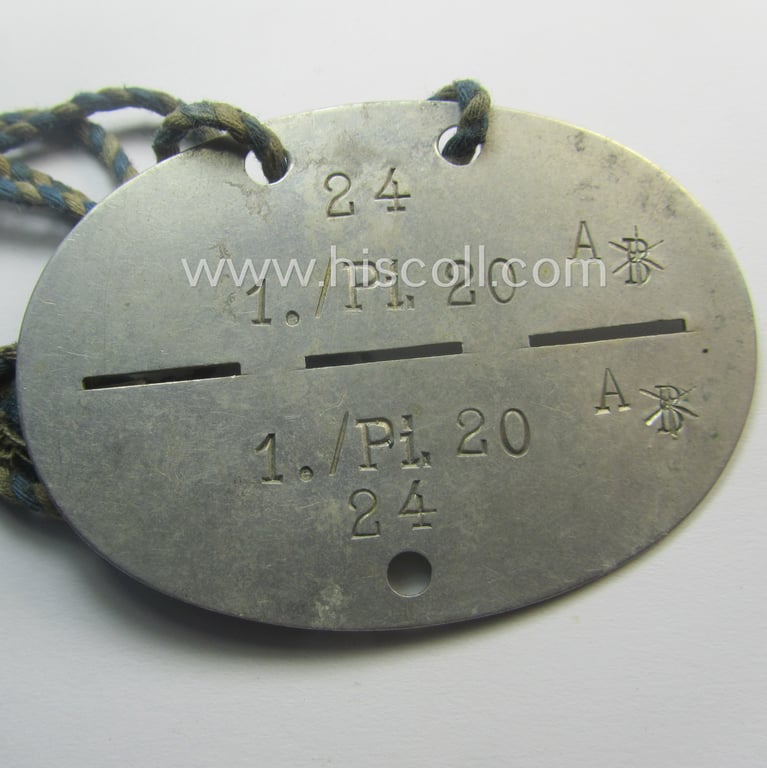 Aluminium-based, WH (Heeres) ie. 'Pionier-Truppen'-related ID-disc: '1./Pi.20' and that comes mounted onto its period cord as worn
