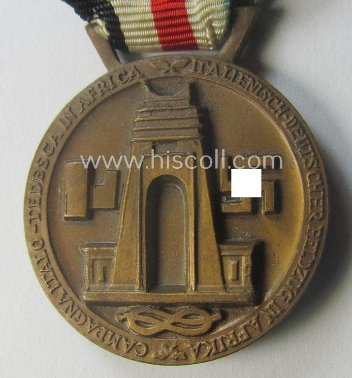 Golden-bronze-coloured- (and I deem 'Buntmetall'-based-) example of a: 'Deutsch-Italienische Feldzugsmedaille' (or: German-Italian campaign-medal) that comes mounted onto its (regular-sized) piece of original (and minimally faded- ie. stained!) r...