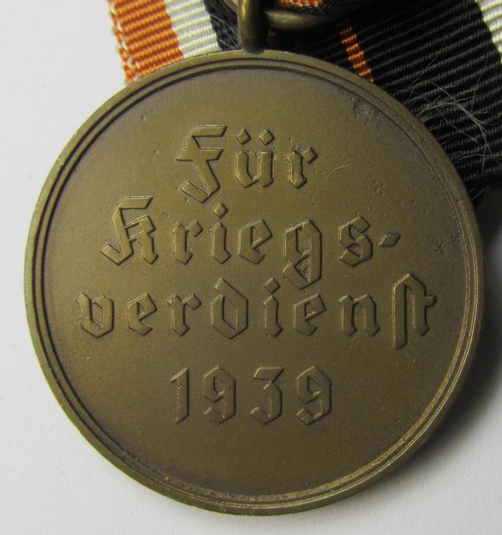Attractive 'Kriegsverdienstmedaille 1939' being a non-maker-marked- (and/or: 'Buntmetall'-based) specimen that came mounted onto its (orange-coloured- and truly long-sized!) ribbon (ie. 'Bandabschnitt')