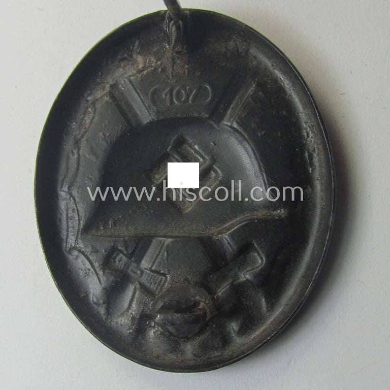 Moderately used - and neatly maker- (ie. '107-) marked - example of a black-class wound-badge (or: 'Verwundeten-Abzeichen in Schwarz') being an example that was produced by the maker (ie. 'Hersteller') named: 'Carl Wild'