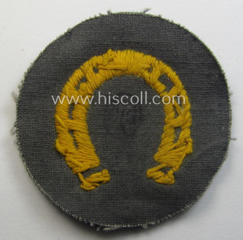 WH (Heeres) so-called: trade- and/or special-career arm-insignia (ie. 'Laufbahn- o. Tätigkeitsabzeichen') as was specifically intended for an army: 'Hufbeschlagmeister' (or farrier) being a neatly hand-embroidered variant on darker-green-coloured...