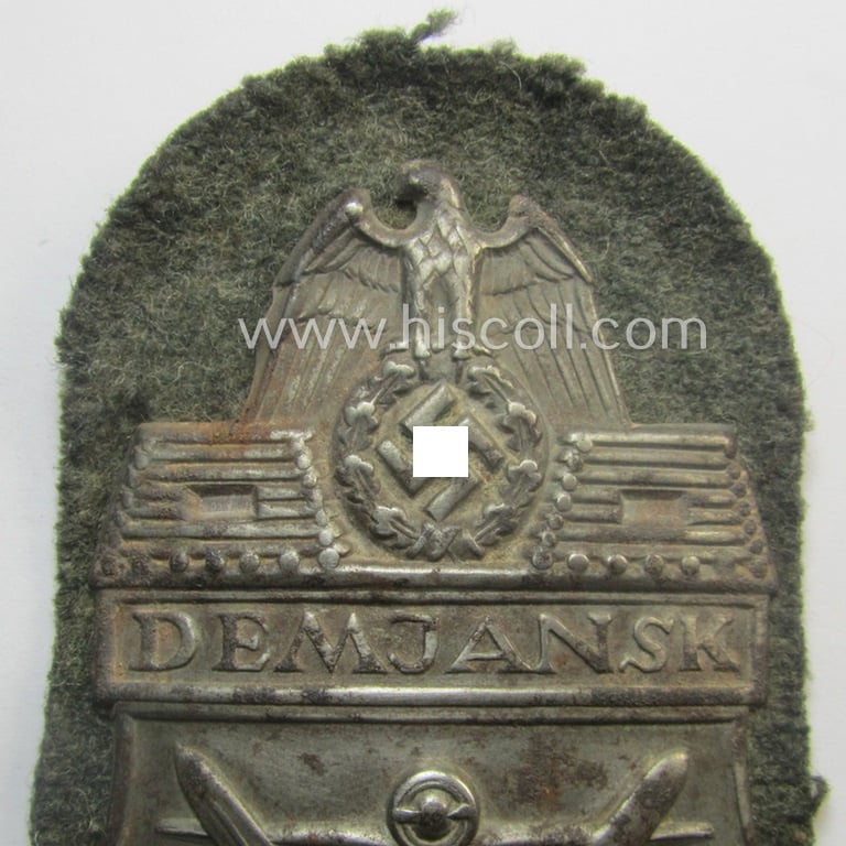 Truly used and/or worn, WH (Heeres ie. Waffen-SS) 'Demjansk'-campaign-shield (of the 'missing log'-pattern) as executed in typical magnetic metal (ie. so-called: 'Eisenblech') and that comes in an overall nice- (ie. fully untouched!), condition
