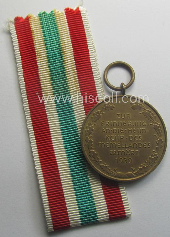 WH Memelland 'Anschluss'- (ie. occupation-) medal: '22 März 1939' (being a minimally used example of the so-called: 'slanted G'-type) that comes together with its original non-confectioned ribbon (ie. 'Bandabschnitt')