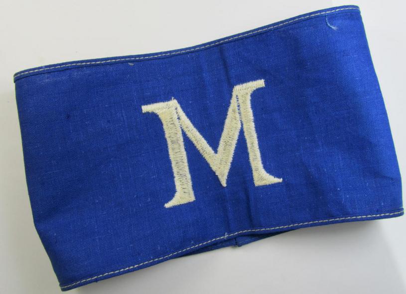Linnen-based- and/or partly machine-woven-, darker-blue-coloured armband (ie. 'Armbinde') depicting a capital 'M'-character, as was presumably intended for staff-members of the German RLB (ie. 'Reichsluftschutz-Bund')