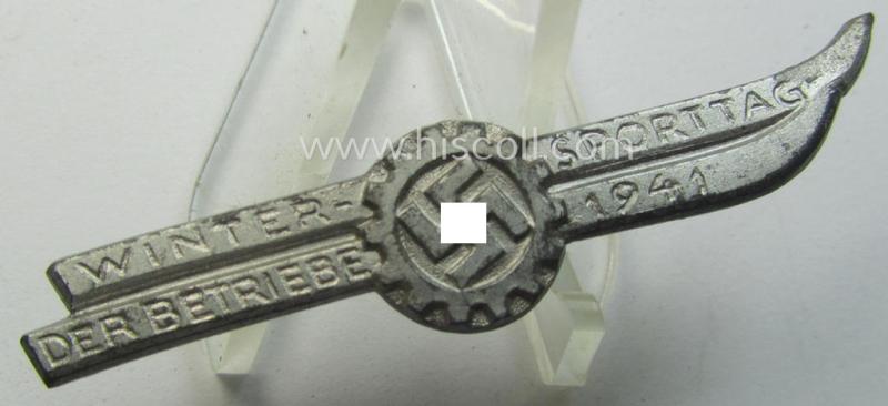 Silver-toned - and/or typical zinc-based - DAF- (ie. 'Deutsches Arbeitsfront'-) related day-badge depicting a pair of ski’s and a so-called: 'DAF-Zahnrad' and text: 'Wintersporttag der Betriebe 1941'