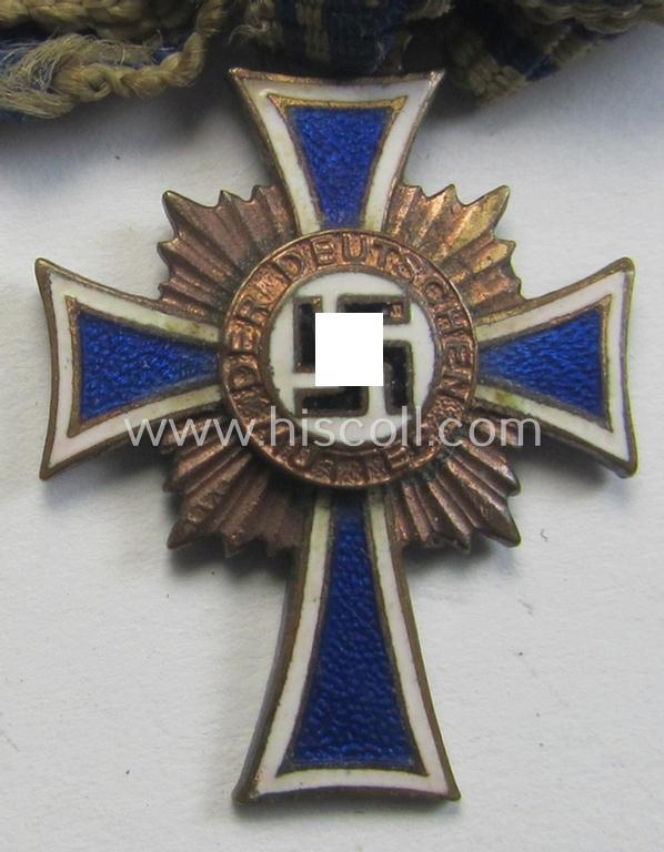 Miniature of an: 'Ehrenkreuz der deutschen Mutter - dritte Stufe' (or: bronze-class mothers'-cross) being a non-maker-marked example that comes in an overall nice- (albeit moderately worn- ie. used-), condition