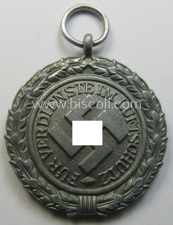 'Luftschutz-Ehrenzeichen 2. Stufe' being a maker- (ie. '10'-) marked example, as executed in (heavy) zinc-based metal (ie. 'Feinzink') and that came together with its period ribbon (ie. 'Bandabschnitt')