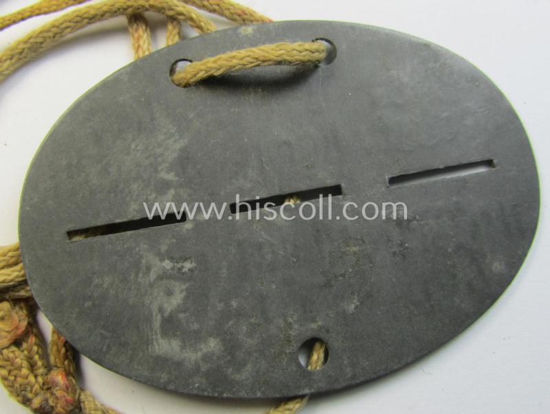 Attractive - and typical zinc-based - WH (Luftwaffe) related ID-disc (ie. 'Erkennungsmarke') bearing the stamped unit-designation that simply reads: 'Kfz.Werkst.Komp.der Lw.VII 107' and that comes mounted onto its period cord as issued & worn