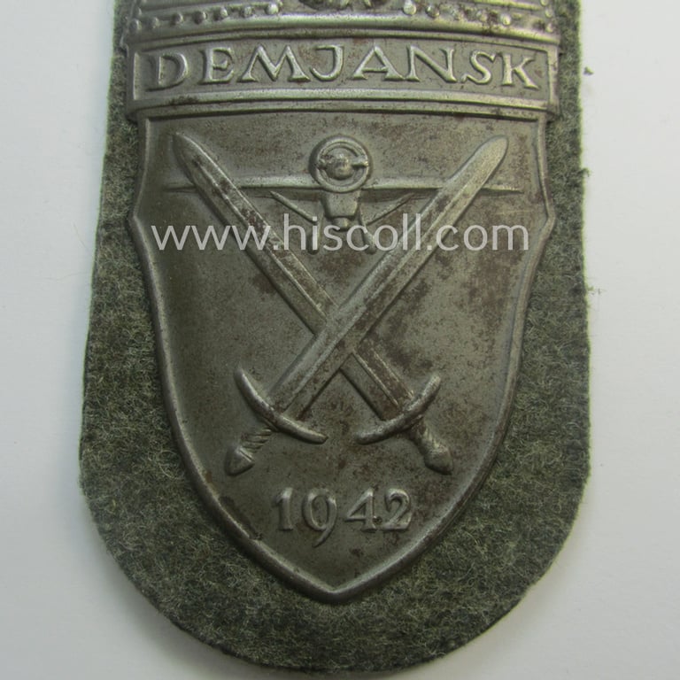 WH (Heeres ie. Waffen-SS) 'Demjansk'-campaign-shield (of the 'missing log'-pattern) as executed in typical magnetic metal (ie. so-called: 'Eisenblech') and that comes in an overall very nice- ie. fully untouched, condition