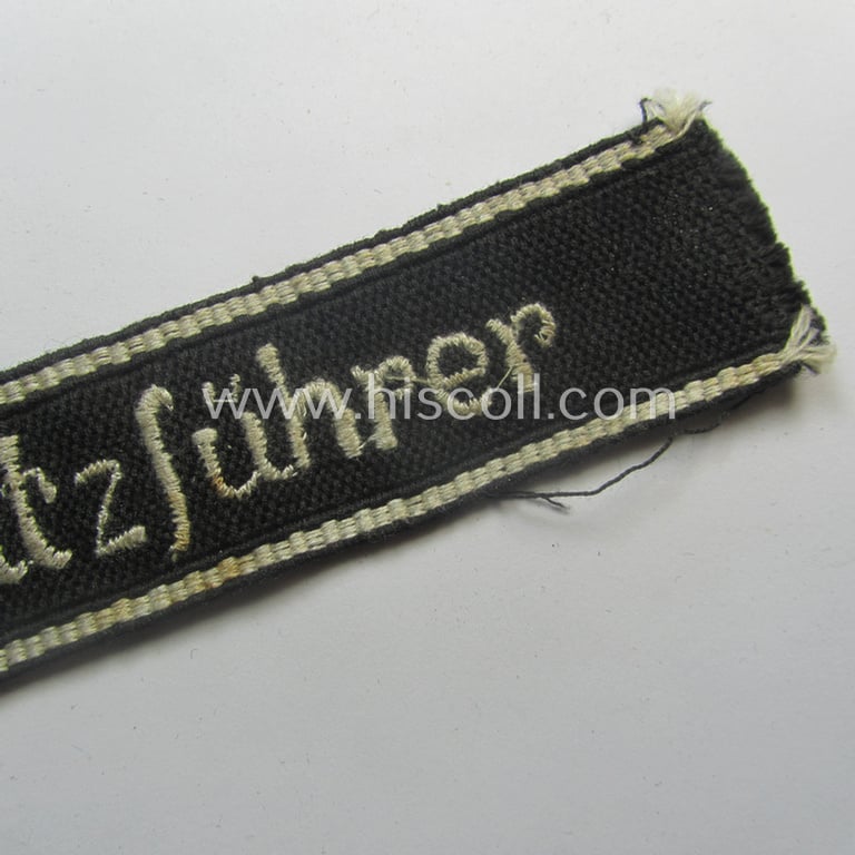 Superb - and actually never before encountered! - example of a HJ/BDM- ('Hitlerjugend' ie. 'Bund Deutscher Mädel'-) cuff-title (ie. 'Ärmelstreifen') entitled: 'Kriegseinsatzführer' being an example as executed in the machine-embroidered pattern