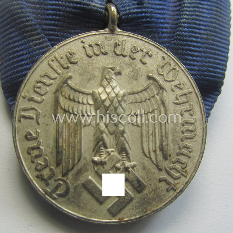 Bright-silver-toned WH (Heeres o. KM) so-called: 'Einzelspange' showing a: 'WH-Dienstauszeichnung 4. Stufe' (as was intended for 4 years of loyal-service) and that shows a detailed, Heeres o. KM-type-eagle-device, period-attached