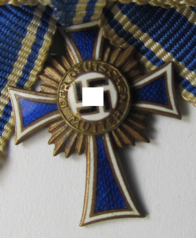 Miniature of an: 'Ehrenkreuz der deutschen Mutter - dritte Stufe' (or: bronze-class mothers'-cross) being a maker- (ie. 'L/14'-) marked example that comes in an overall nice- (albeit moderately worn- ie. used-), condition