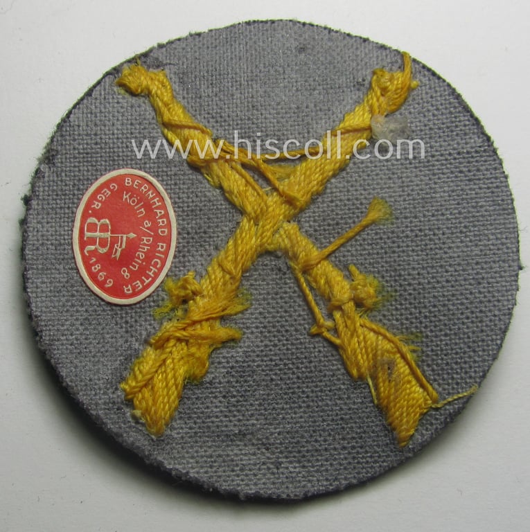 WH (Heeres) hand-embroidered, trade- ie. special-career arm-patch as was intended for a: 'Waffenmeister' (or: weapon-equipment NCO) being a maker-marked(!) example as executed on darker-green-coloured wool