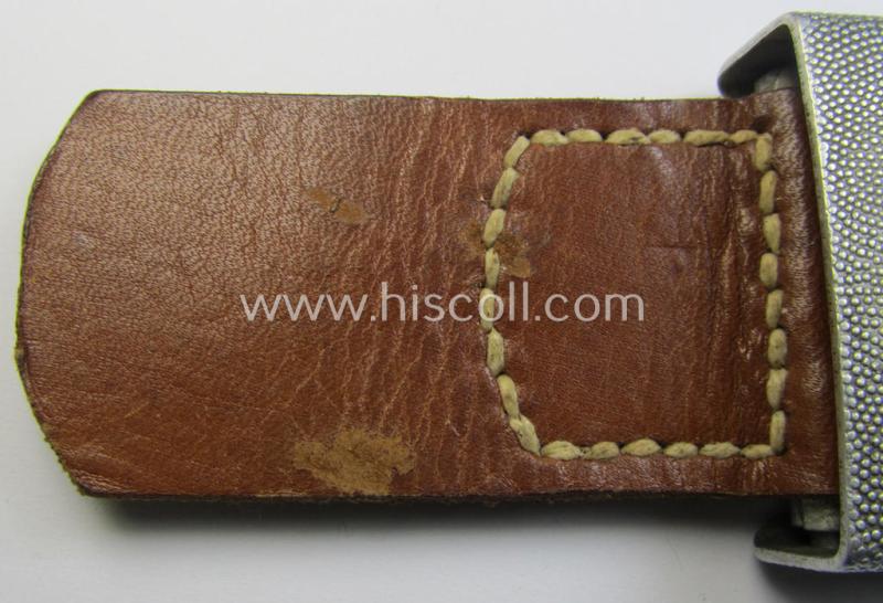 Attractive, WH (Luftwaffe) silver-coloured and aluminium-based belt-buckle, being a maker- (ie. 'F.W. Assmann & Söhne'-) marked example that comes mounted onto its leather-based tab and that comes in a minimally used condition