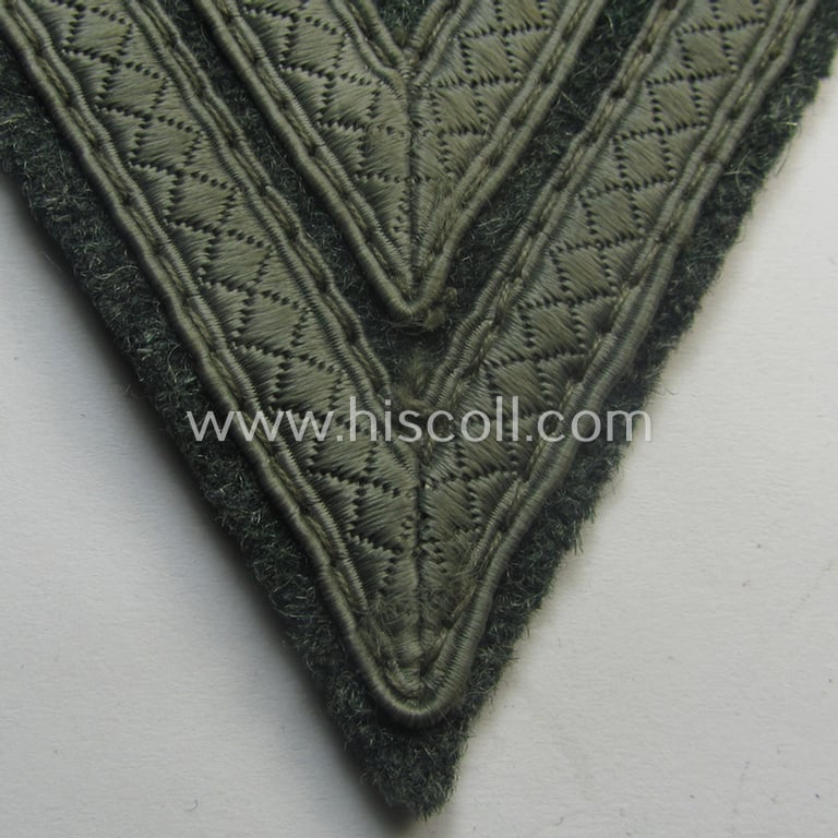 WH (Heeres) 'Armwinkel' (or: arm-chevron) as executed on typical field-grey-coloured wool as was specifically intended for usage by a soldier with the rank of: 'Obergefreiter'