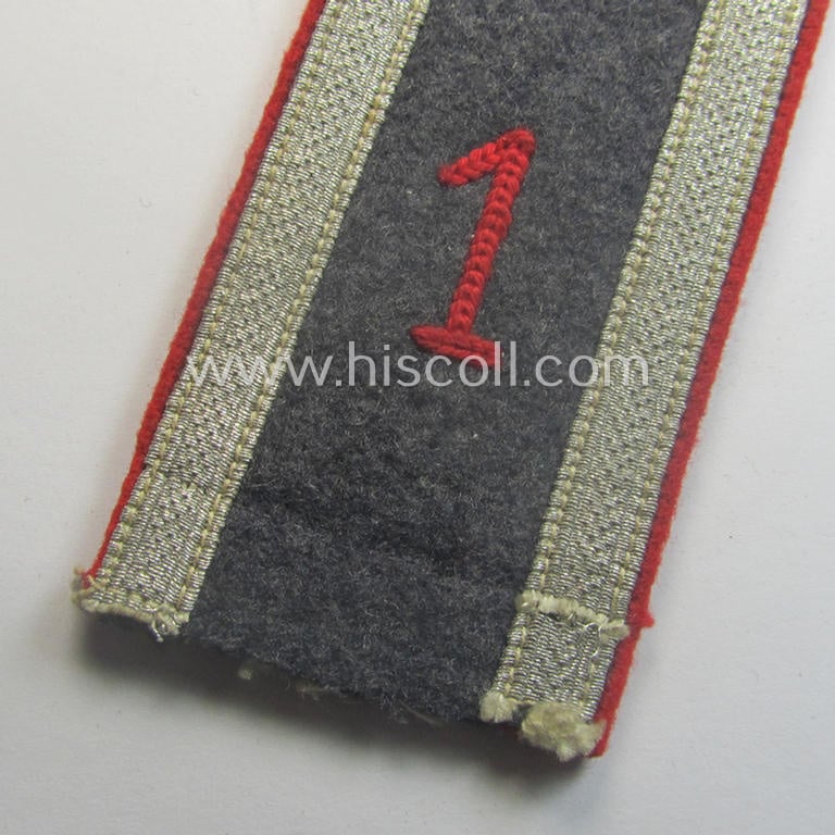 Single, WH (LW) 'cyphered', NCO-type shoulderstrap as piped in the bright-red-coloured branchcolour as intended for usage by an: 'Uffz.' who served within the: 'Flak-Artillerie-Abtgs. 1'