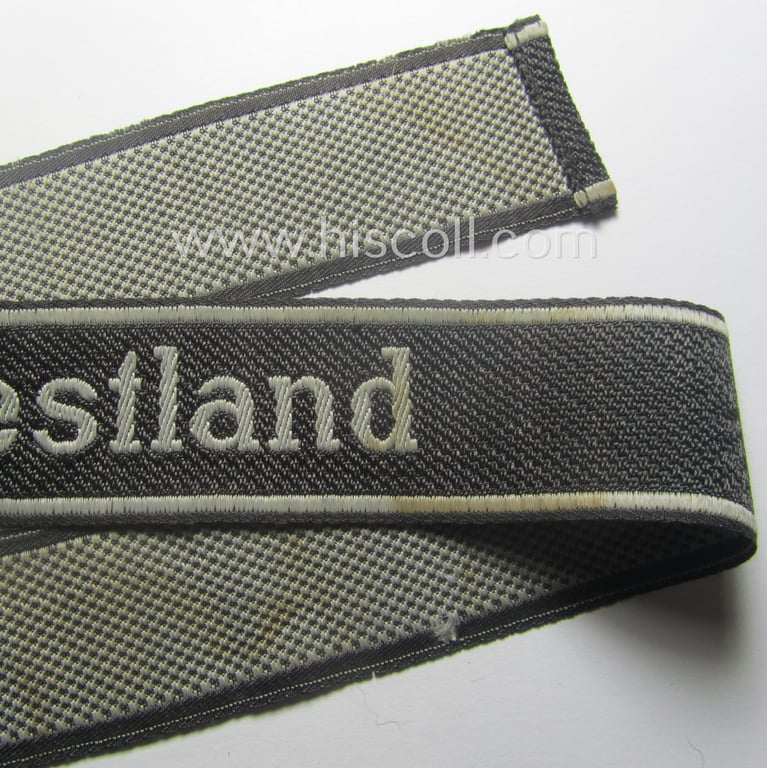 Waffen-SS, 1943/44 pattern cuff-title (ie. 'Ärmelstreifen') depicting the machine-woven Latin script text in silver-grey linnen as was intended for a member of the: 'SS-Regiment': "Westland" (ie. part of the: '5. SS-Pz-Gren.-Div. "Wiking")