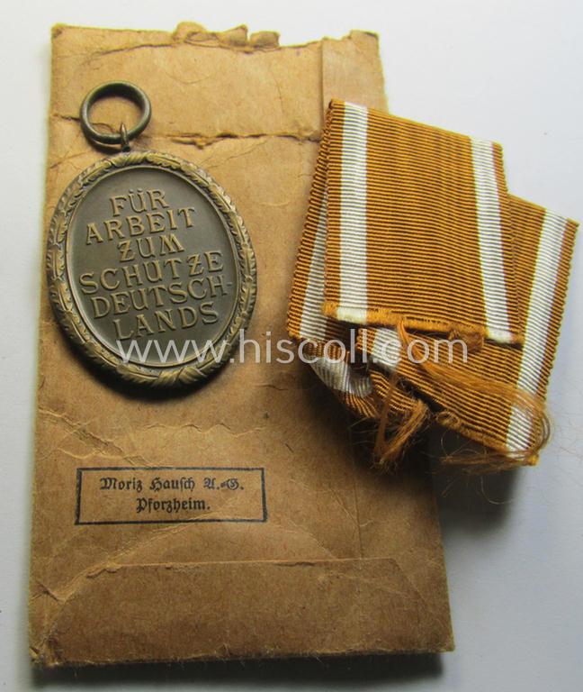 Attractive medal-set: 'Deutsches Schutzwall Ehrenzeichen' (aka: 'Westwall'-medal) being a typical non-maker-marked- and/or 'Buntmetall'-based specimen that comes packed in its original pouch of issue by the: 'Moritz Hausch A.G.'-company