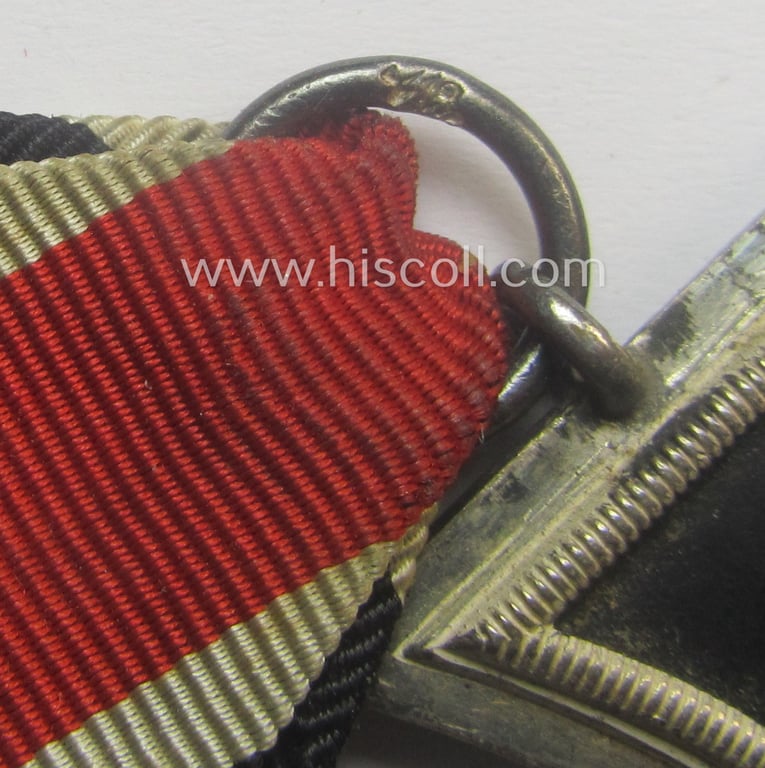 'Eisernes Kreuz II. Klasse' being a neatly maker- (ie. 'L/18'-) marked example that comes mounted onto its period- and confectioned ribbon (ie. 'Bandabschnitt') as was produced by the maker (ie. 'Hersteller'): 'B.H. Mayer's Kunstprägeanstalt'