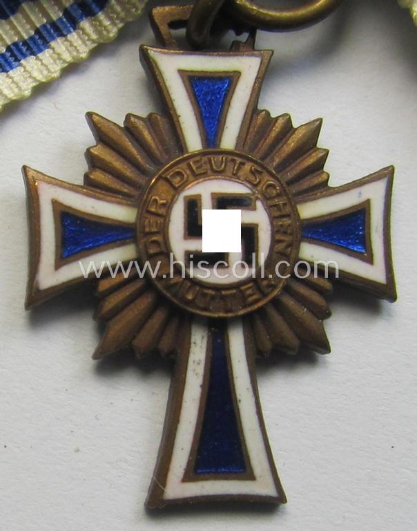 Miniature of an: 'Ehrenkreuz der deutschen Mutter - dritte Stufe' (or: bronze-class mothers'-cross) being a maker- (ie. 'L/10'- ie. 'Deschler'-) marked example that comes in an overall nice- (albeit moderately worn- ie. used-), condition