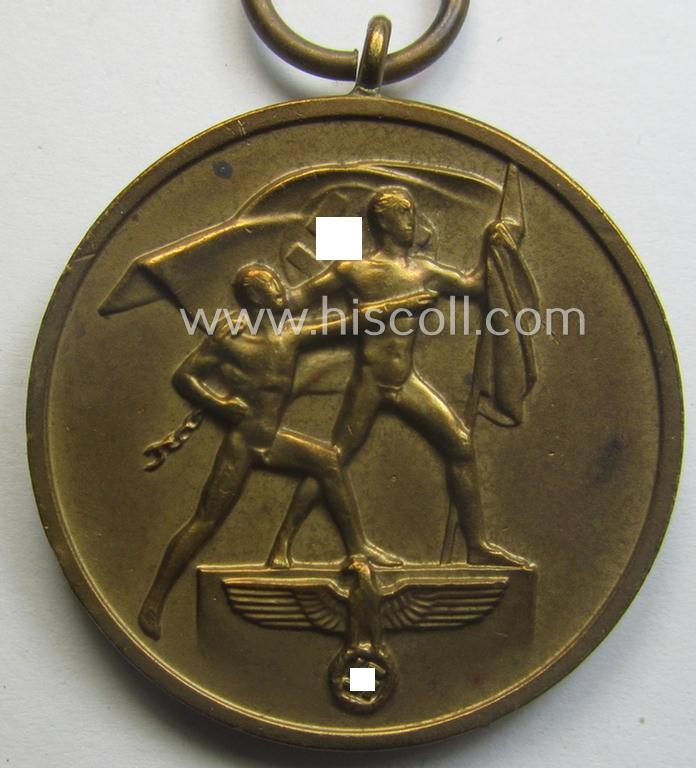 WH Memelland 'Anschluss'- (ie. occupation-) medal: '22 März 1939' (being a minimally used example of the so-called: 'slanted G'-type) that comes together with its original non-confectioned ribbon (ie. 'Bandabschnitt')