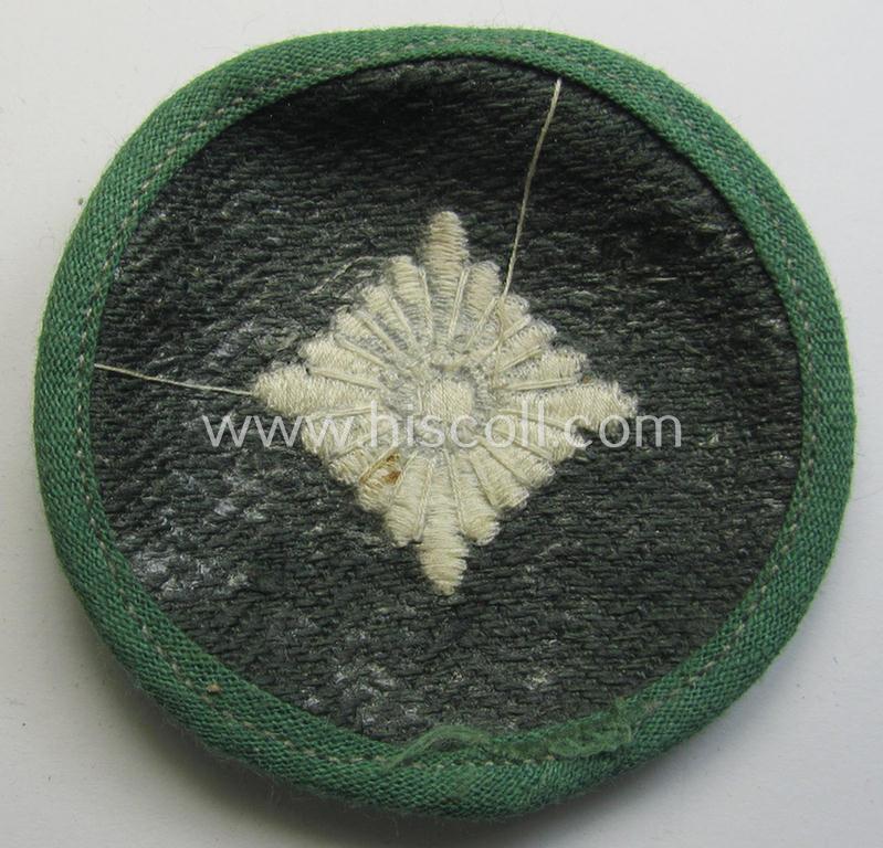 Attractive, WH (Heeres) rank-insignia (ie. arm-roundel) as was specifically intended for usage by an: 'Oberschütze' (being an interesting example as executed in silverish-grey-coloured linnen onto a 'HBT'-type, greenish-coloured background)