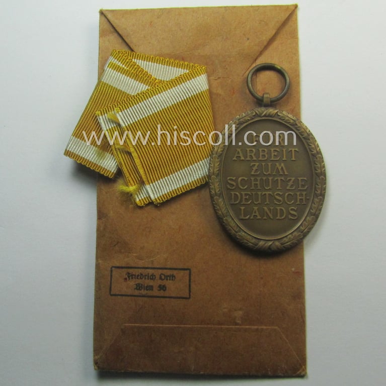 Medal-set: 'Deutsches Schutzwall Ehrenzeichen' (aka: 'Westwall'-medal) being a (typical) non-maker-marked- and/or: typical 'Buntmetall'-based specimen that comes packed in its original pouch of issue by the: 'Friedrich Orth'-company