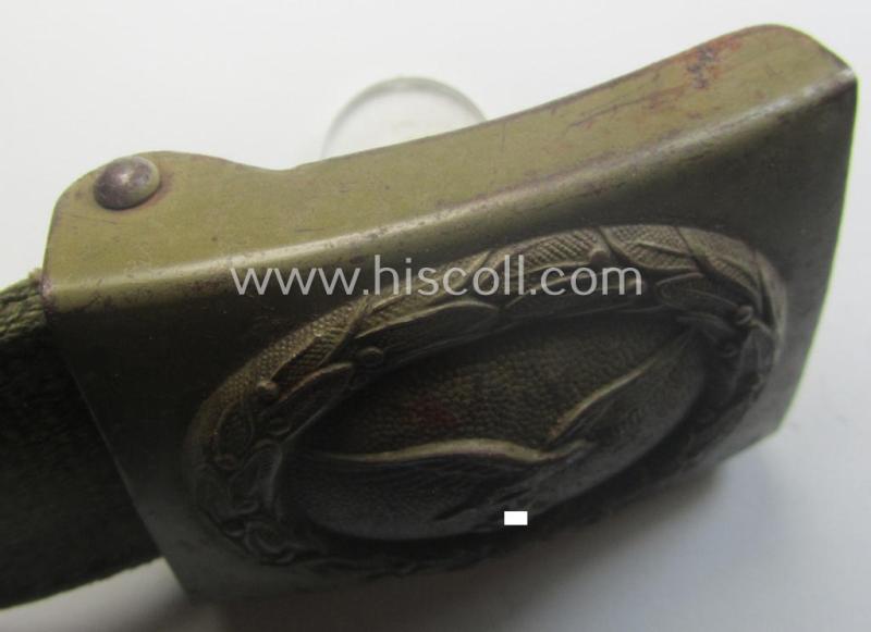 Rarely found WH (Luftwaffe) 'tropical-issued' belt-buckle being a non-maker-marked, beige-tan-coloured example that comes mounted onto its original, greenish-coloured- (and/or: 'webbing'-based-) tab