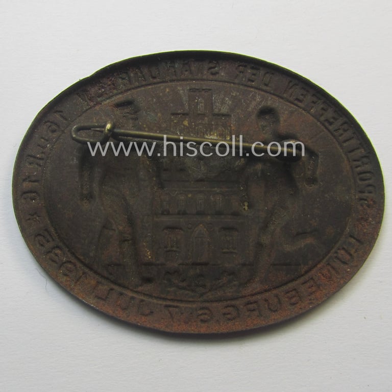 Commemorative, golden-bronze-coloured 'SA- o. Sturmabteilungen'-related 'tinnie' being a non-maker-marked example showing two detailed SA-member, towns'-building and text: 'Sporttreffen der Standarten 16 u. R16 - Lüneburg - 6. u. 7. Juli 1935'