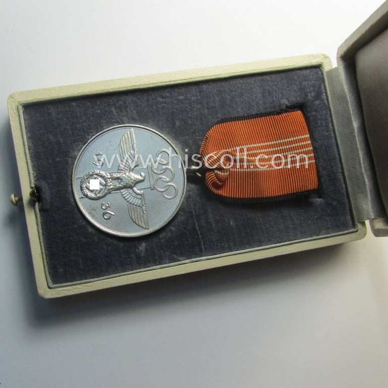 Superb, 'Deutsche Olympia-Erinnerungsmedaille 1936' being a non-maker-marked example that comes mounted onto its original ribbon (ie. 'Bandabschnitt') and that comes stored in its typical, beige-white-coloured etui