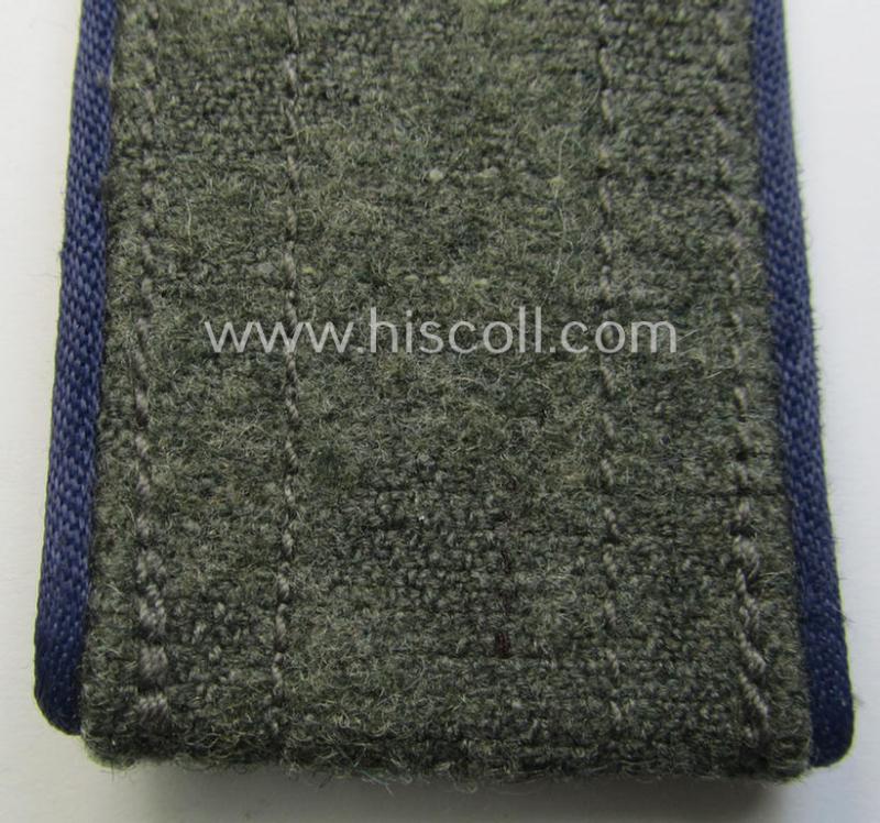 Single, later-war-period, so-called: 'M44'-pattern, simplified WH (Heeres) enlisted-mens'-type shoulderstrap as piped in the darker-blue-coloured branchcolour as was intended for usage by a: 'Soldat der Sanitäts-Truppen'