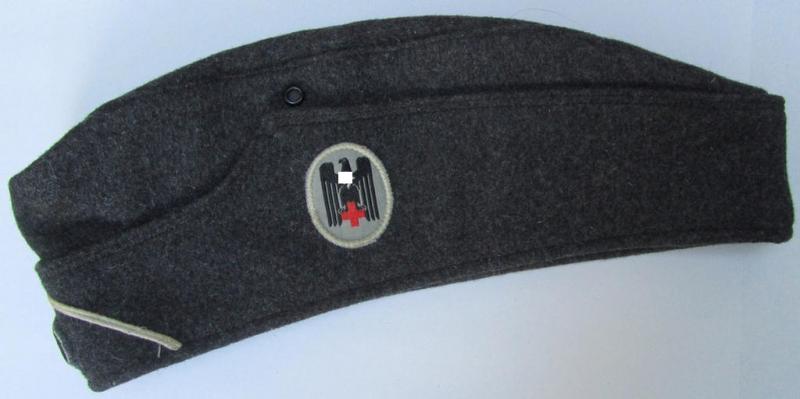 Attractive, typical darker-greyish-blue-coloured, so-called: German Red Cross (ie. 'Deutsches Rotes Kreuz' or: 'DRK' EM- (ie. NCO-) type side-cap (ie. 'Schiffchenmütze für Mannschaften u. Unteroffiziere des deutschen Rotes Kreuzes')