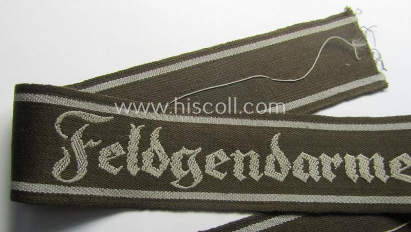 Superb - and scarcely encountered! - example of a WH (Heeres) cuff-title ie. armband (ie. 'Ärmelstreifen') entitled: 'Feldgendarmerie' (being a typical 'semi-BeVo'-woven!) example that comes in a full length- ie. non-shortened, condition