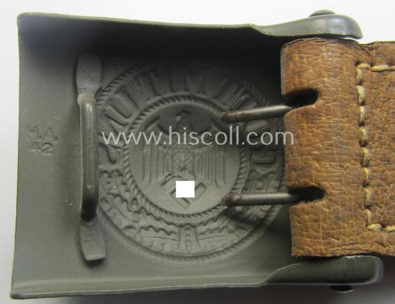 WH (Heeres) 'standard-pattern', field-grey-toned- and steel-based belt-buckle being a maker- (ie. 'H. Arld - Nuernberg'-) marked- and/or: '1942'-dated example that comes mounted onto its leather- (ie. 'pig-skin'-) based tab