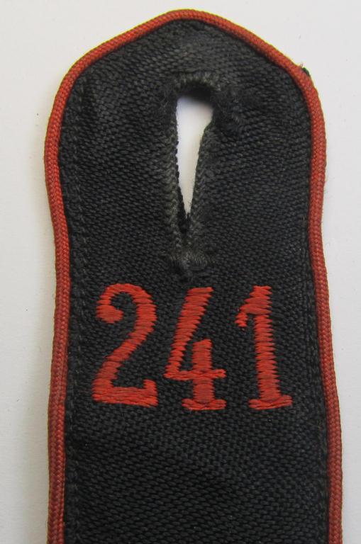 Moderately worn - albeit regrettably single! - bright-red-piped so-called: 'Allgemeine-HJ'-shoulderstrap as intended for an: 'HJ-Scharführer' who served within the 'Bann 241' (241 = 'Bann Oberbergisch' situated in the 'Gebiet West-Mittelrhei...