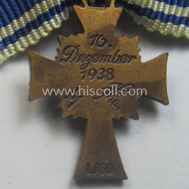 Attractive, 2-cms.-sized miniature of a maker- (ie. 'L/60'- ie. by 'GB'-) marked: 'Ehrenkreuz der Deutschen Mutter in Bronze' that came stored in its non-maker-marked, two-pieced bordeaux-coloured 'LDO'-type box (ie. etui)