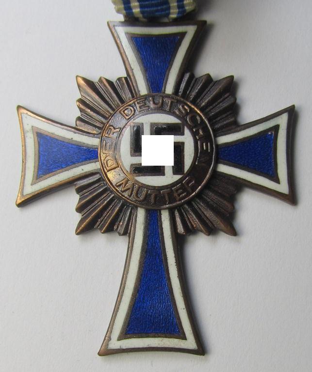 Attractive, 'Ehrenkreuz der deutschen Mutter - dritte Stufe' (or: bronze-class mothers'-cross) that came mounted onto its long-sized ribbon and that came stored in its period pouch (by the maker: 'Jakob Bengel - Idar-Oberstein')