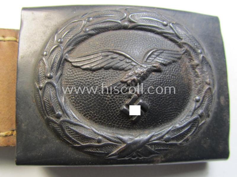 WH (Luftwaffe) bluish-grey-coloured, steel-based belt-buckle, being a maker- (ie. 'H. Aurich'-) marked- and/or: '1942'-dated example that comes mounted onto its leather-based tab and that comes in a 'virtually mint' condition