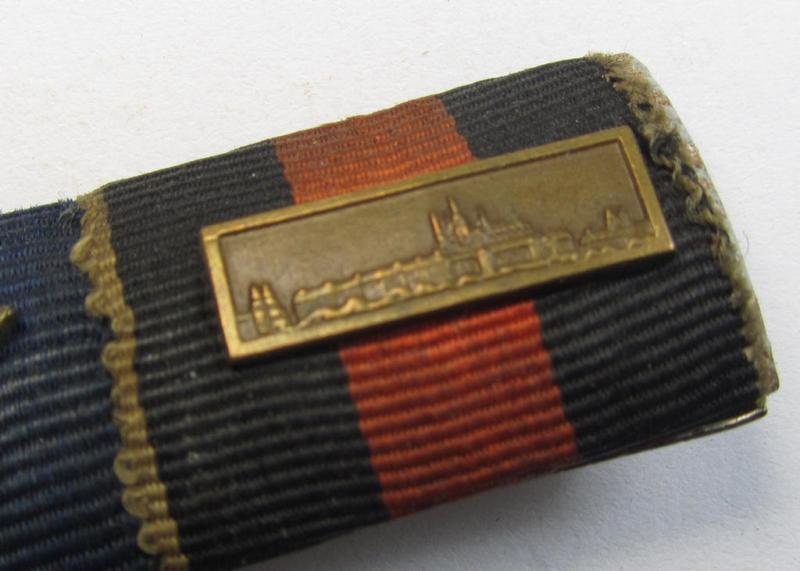 Two-pieced WH (Luftwaffe) ribbon-bar (ie. 'Band- o. Feldspange') showing resp. the ribbons for a (WH) DA 4. Stufe (with LW-eagle-device) and a Czech 'Anschluss'-medal (showing a detailed miniature 'Prager Burg-Spange' attached)